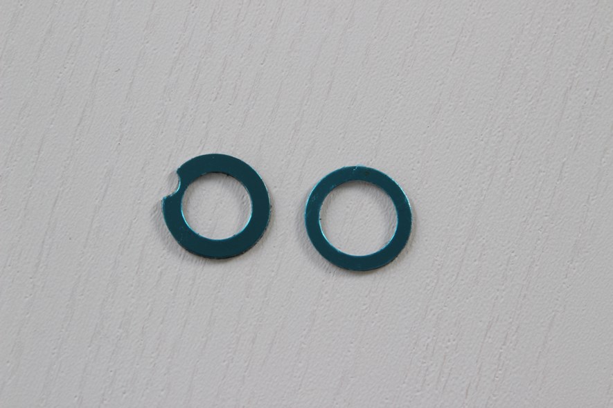 These metal rings have a sticky back for attaching to the cell phone (non-permanent). They are shaped a bit differently - the one with the notch could be used if the flash is close to the lens, so that it will not cover it.